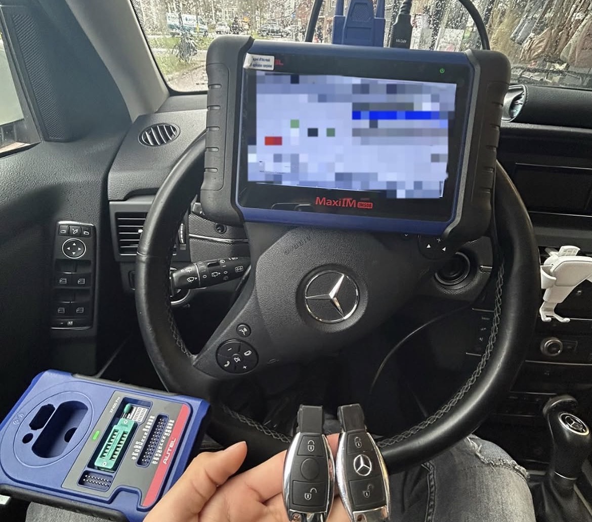 Autosleutels en een programmeertablet in een Mercedes-Benz interieur